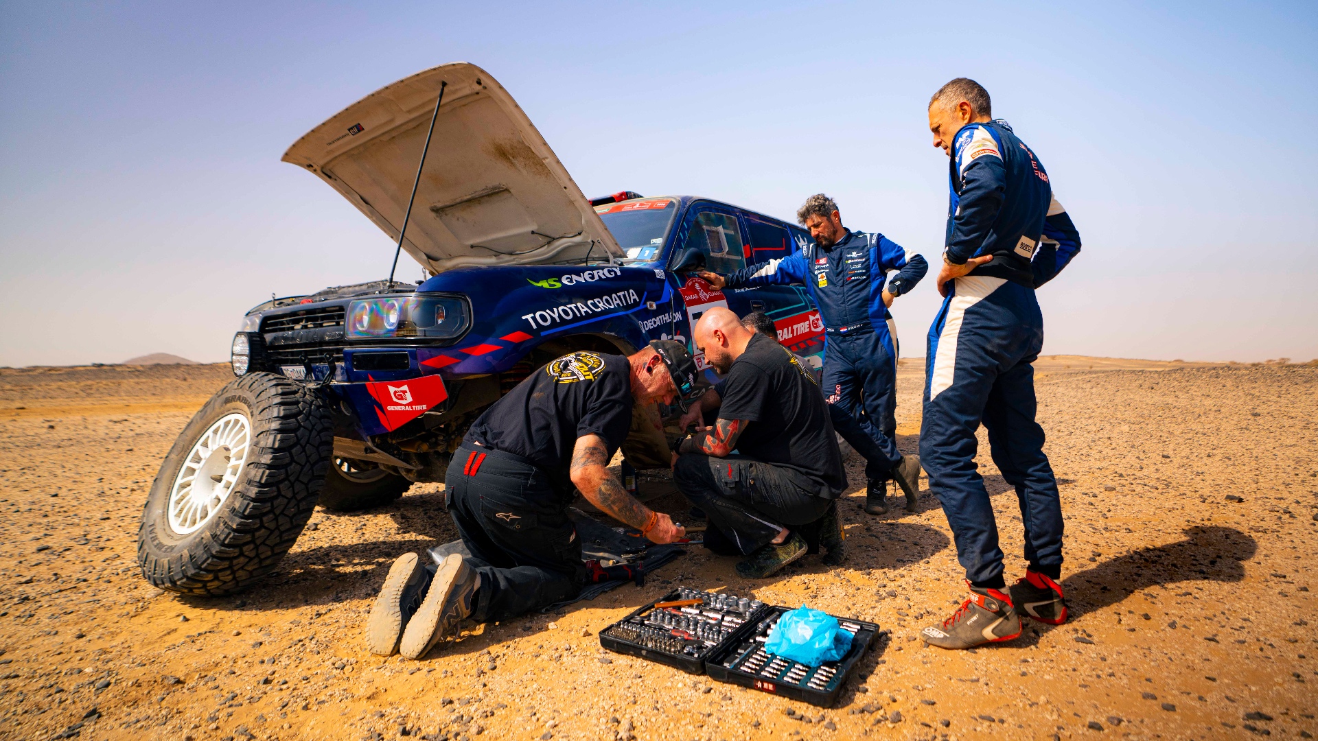 Crew repairing a Toyota in the desert