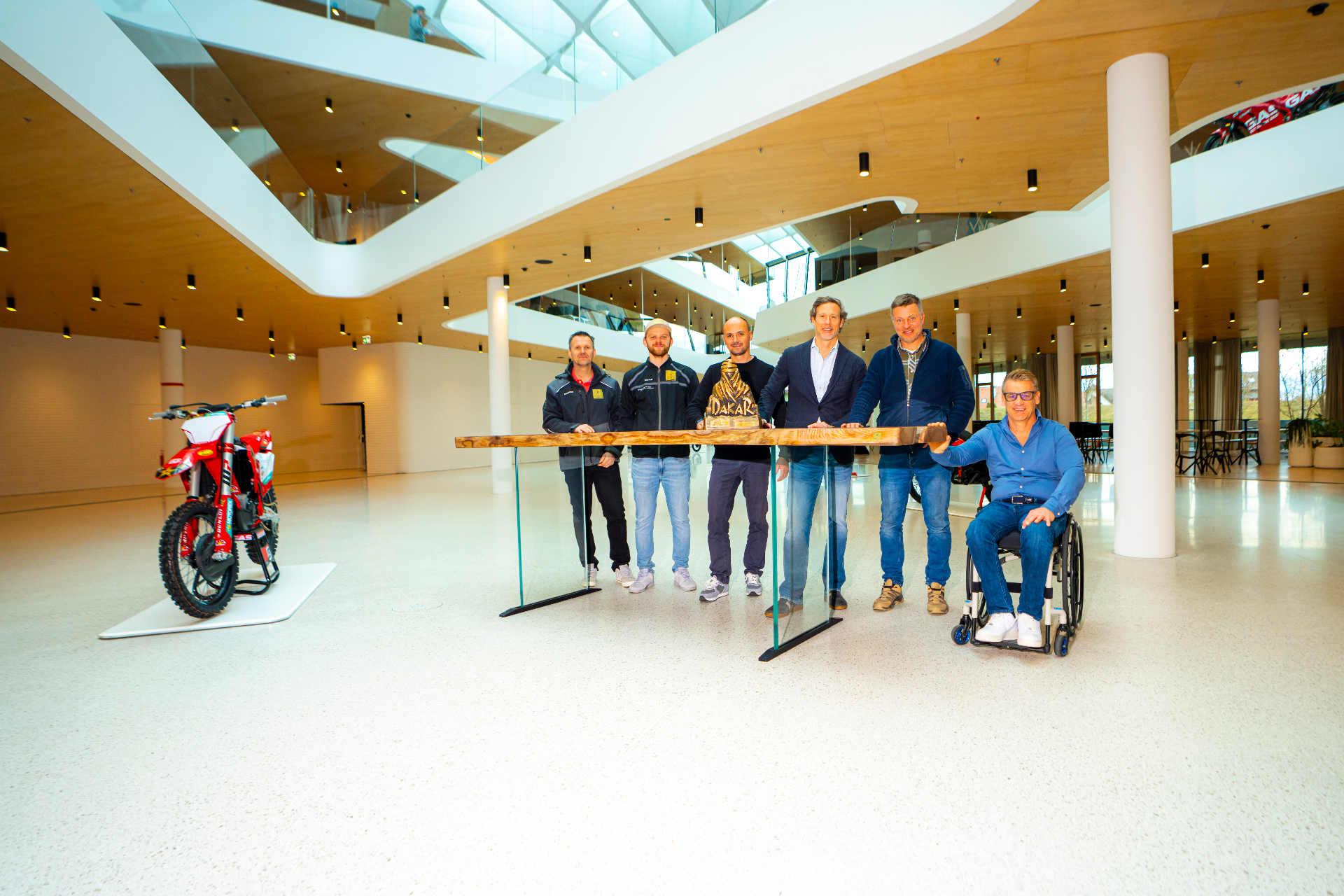 Team gathered around the table with the Dakar trophy